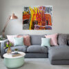 A Splash of Life abstract painting by Yelena Revis above a grey sectional sofa in a modern living room
