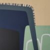 Detail of stitched-line accents along a navy curved shape on textured beige in Blue Fog by Yelena Revis
