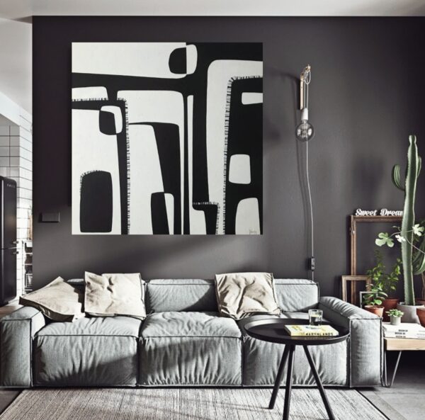 Large black and white abstract painting named Contrasts by Yelena Revis hanging on a dark wall above a gray sofa in a modern living room.