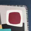 Detail of a maroon rounded square framed in white over textured grey in White Night by Yelena Revis